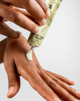 Applying Sister's Aroma Smart Hand Cream with avocado on a hand, showcasing its moisturizing properties.