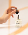 Ruka otevírající unisex parfém Under Skin 50 ml s elegantním designem na bílém pozadí.