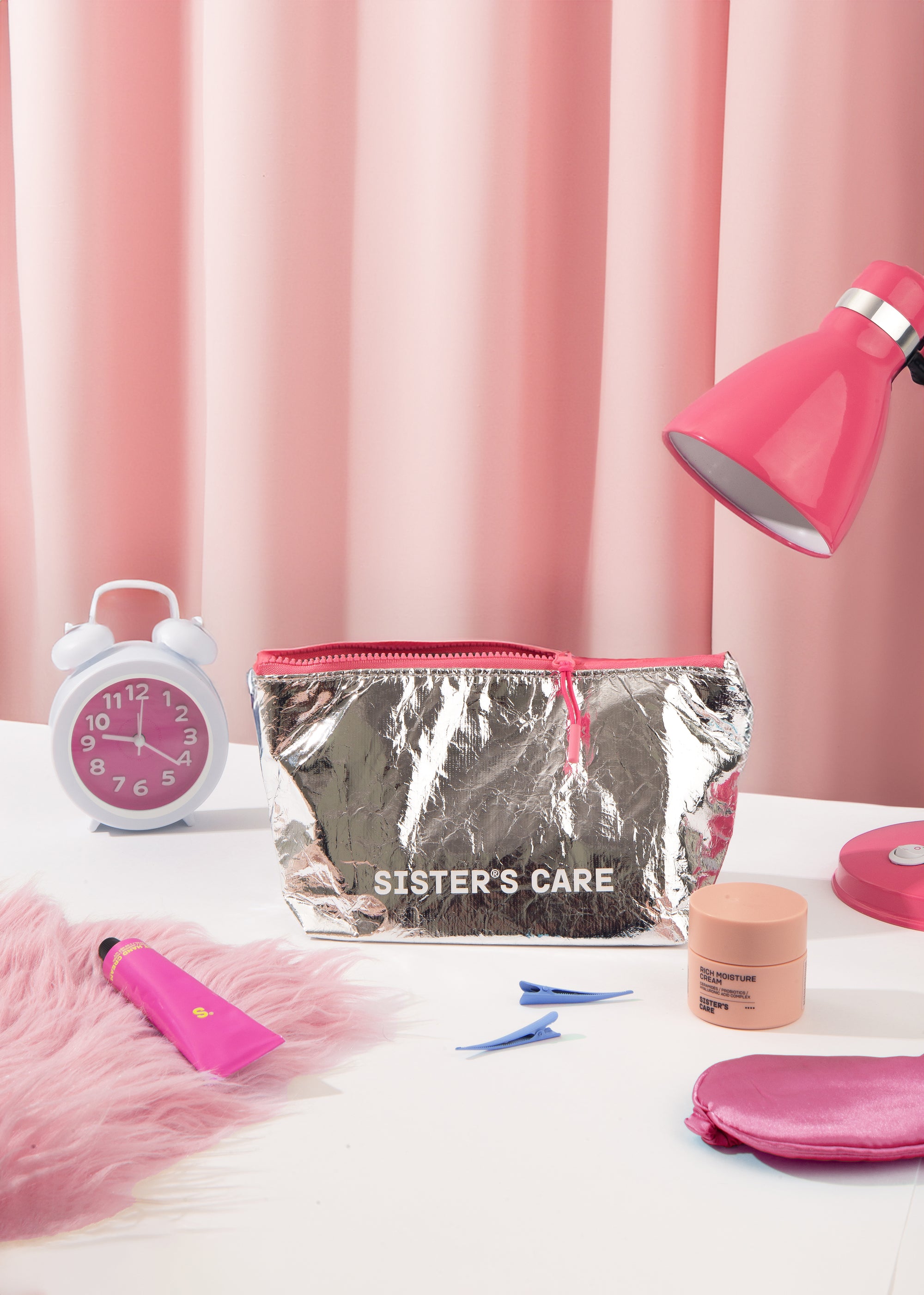 Sister's Aroma Cosmetic bag in metallic finish displayed on a table with beauty products, creating a chic and functional vibe.
