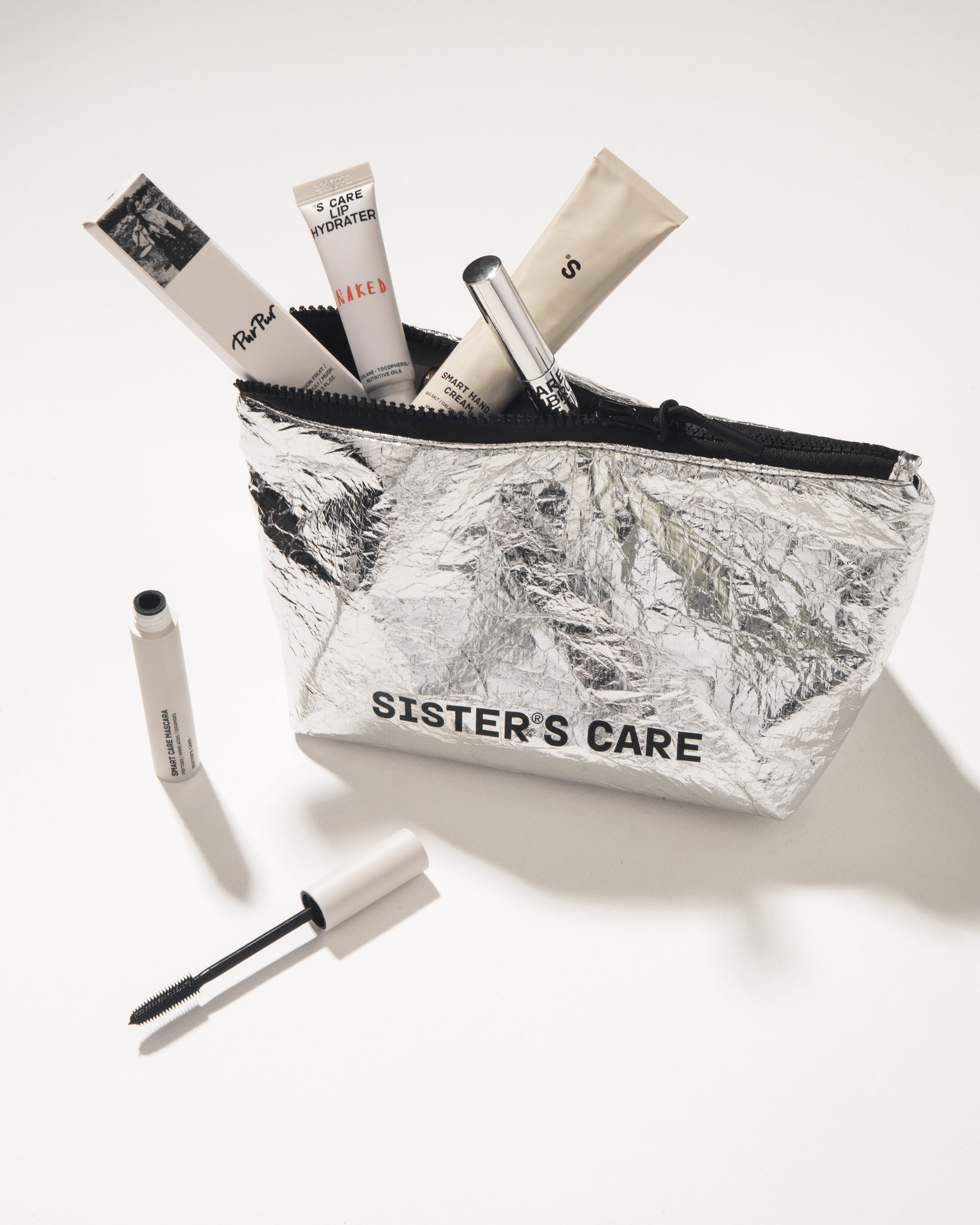 Sister's Aroma Cosmetic bag in silver, filled with beauty products, showcasing functional beauty on the go.