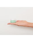 Rare Paris Elixir Intense Eye Serum showcased in a hand against a neutral background.