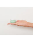 Rare Paris Elixir Intense Eye Serum showcased in a hand against a neutral background.