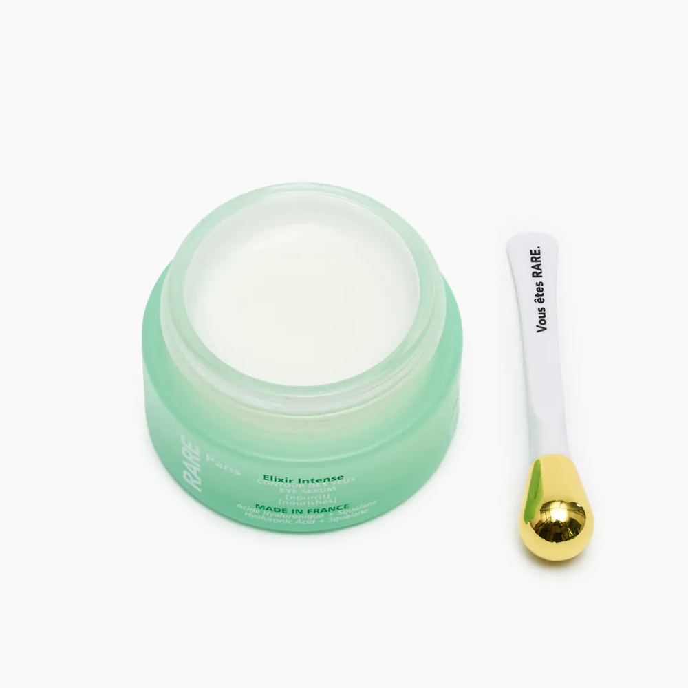 Rare Paris Elixir Intense Eye Serum in green jar with application spatula, designed for nourishing eye care.