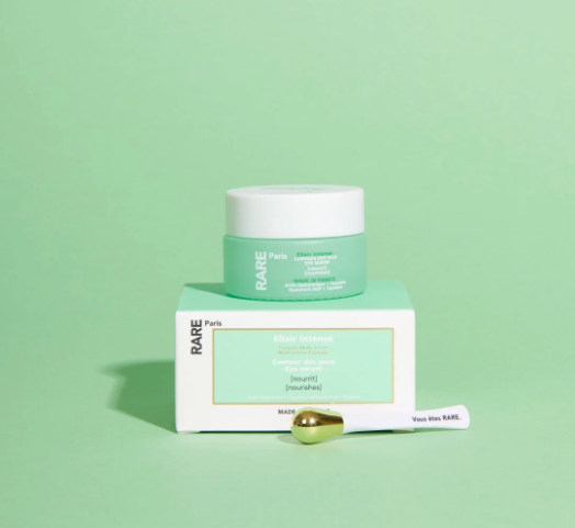Rare Paris Elixir Intense Eye Serum with golden applicator on a green background, enhancing eye skin nourishment.
