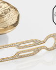 Fiona Franchimon Nº1 HAIRPIN Steel with Swarovski® Crystals | Yellow Gold Finish showcased next to a decorative piece.