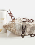 Fiona Franchimon Nº1 HAIRPIN PETITE | Brown hnědé (5 ks) on a rock with elegant packaging.